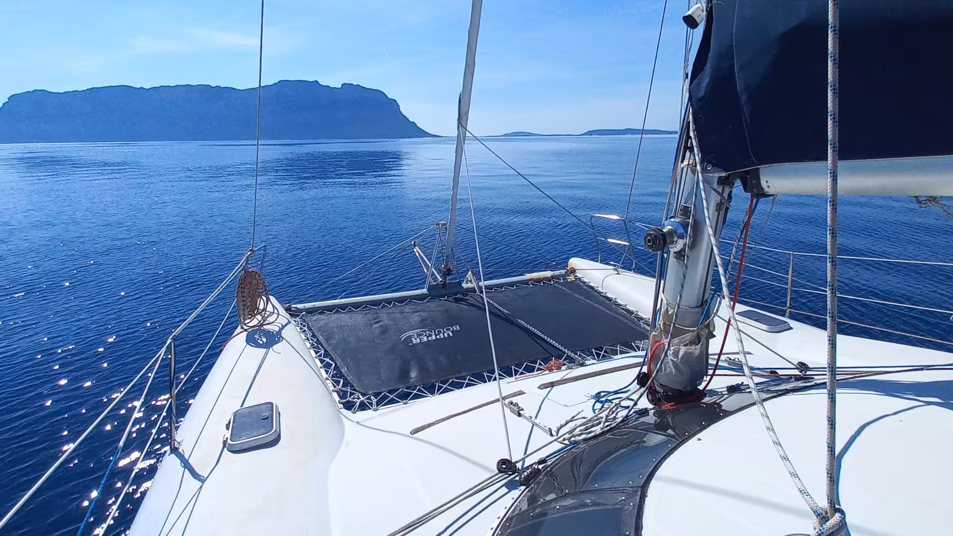 Catamaran sailing towards Tavolara Island, showcasing clear blue waters and a sunny sky near Olbia.
