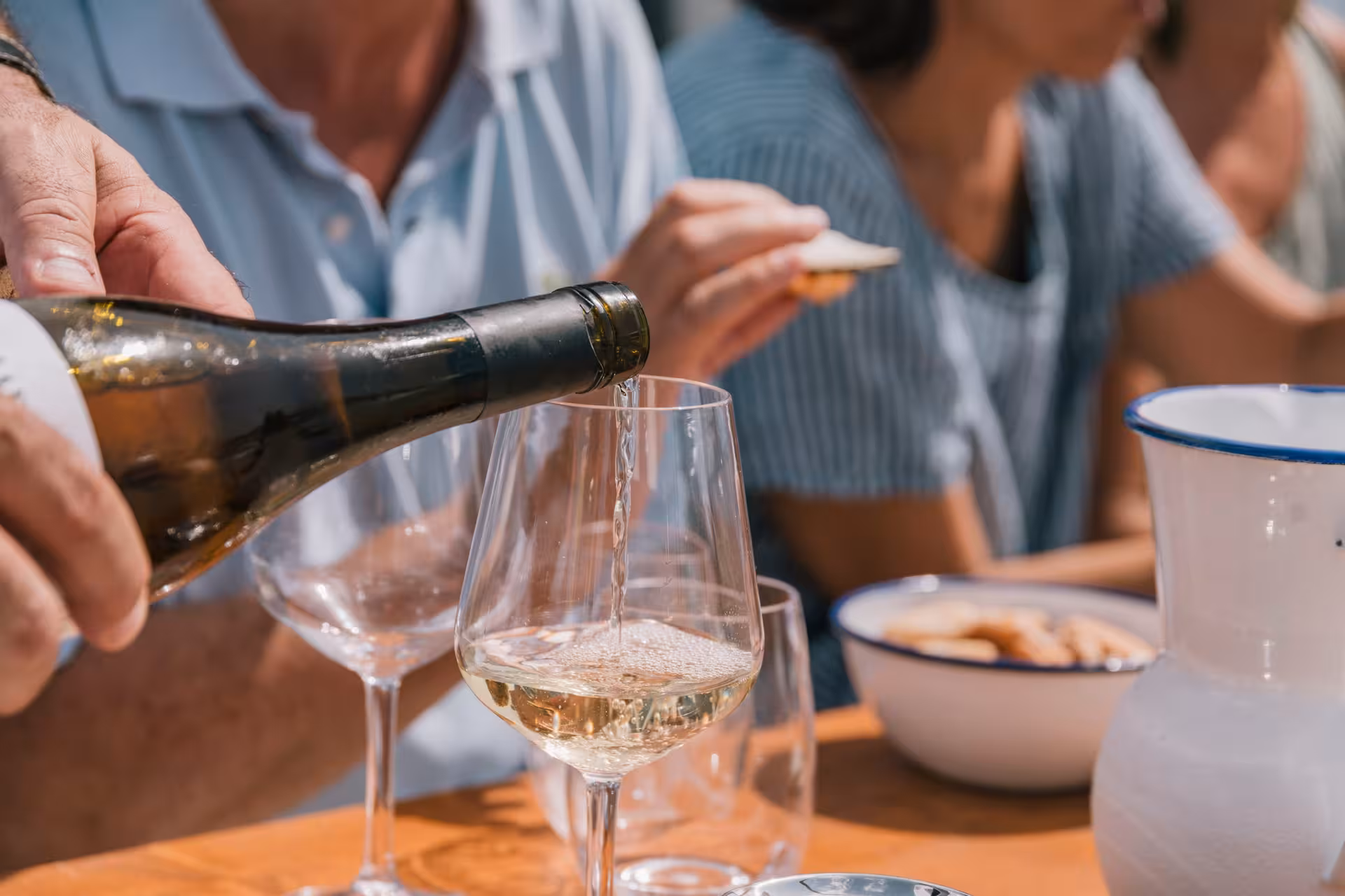 Pouring chilled cava into wine glass during private luxury catamaran Barcelona Bali 4.1 cruise with tapas