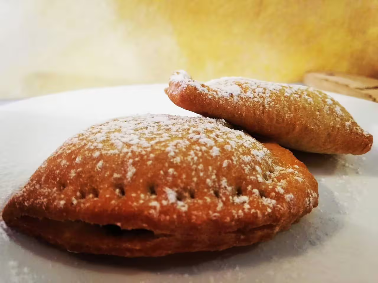 Freshly fried Cecio Ripieno pastries dusted with powdered sugar, traditional Italian stuffed dessert tasting