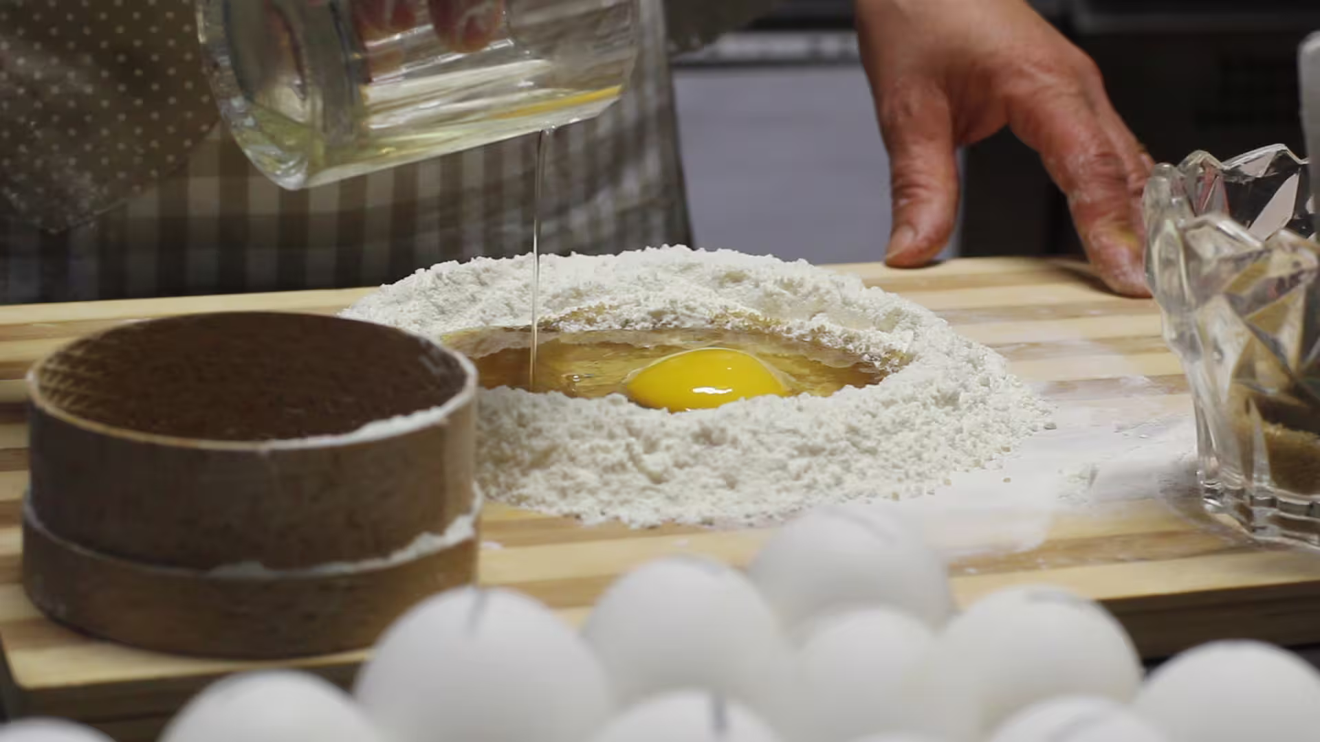 Close-up of oil poured into egg and flour well for Cecio Ripieno, authentic Italian show cooking demo