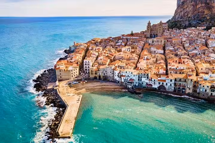 Aerial view of Cefalù coast and old town by turquoise sea on a private half-day trip from Palermo
