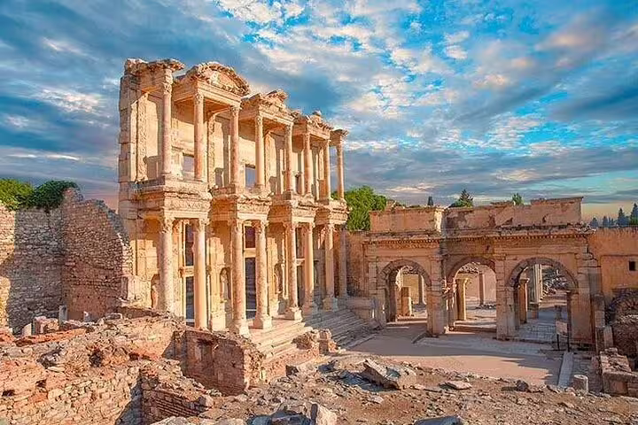 The majestic Celsus Library in Ephesus under a vibrant sky, showcasing ancient Roman architecture and ruins.