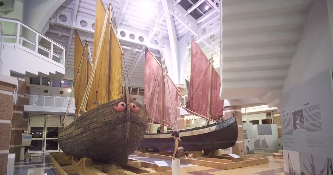 Visitor viewing vintage sailboats at Cesenatico Maritime Museum, key stop on Marino Moretti House tour