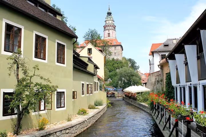 Canal-side view of Cesky Krumlov with castle tower, featured on small-group day trip from Vienna