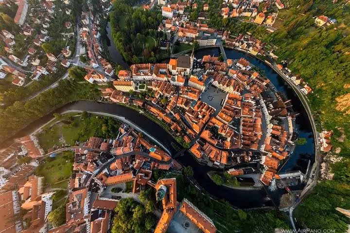 Drone panorama of Cesky Krumlov UNESCO center with river loop, highlight stop on Salzburg to Prague private transfer