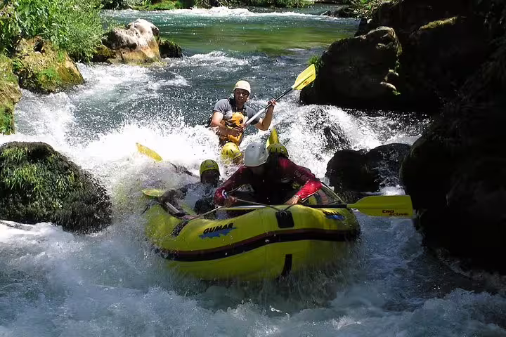 Adventure rafting Cetina River from Makarska Riviera, yellow raft tackling rocky rapids with guide and transfer
