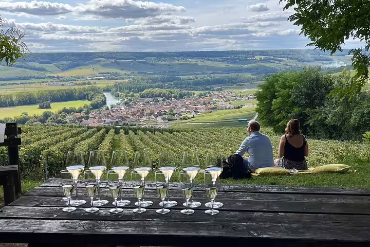 Champagne flutes on table overlooking Reims vineyards, scenic Champagne and Reims tasting day trip from Paris