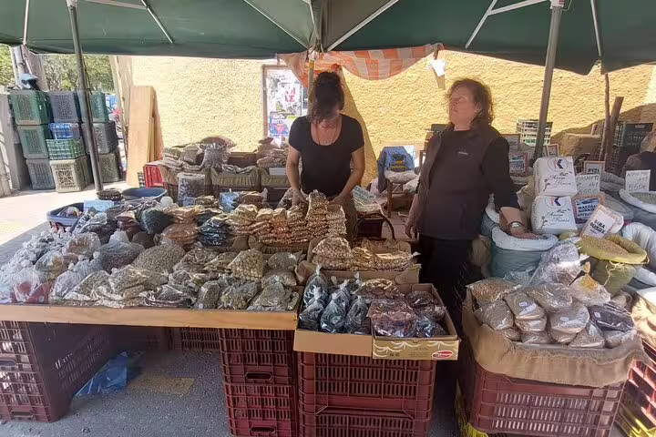 Vendors offer a variety of spices and dried goods at Chania's lively outdoor farmers market.