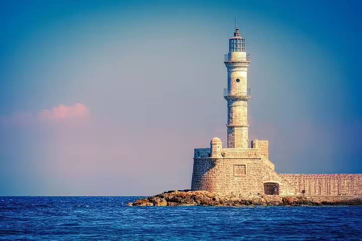 Picturesque view of Chania's iconic lighthouse on a clear day, surrounded by the deep blue waters of the Aegean Sea.