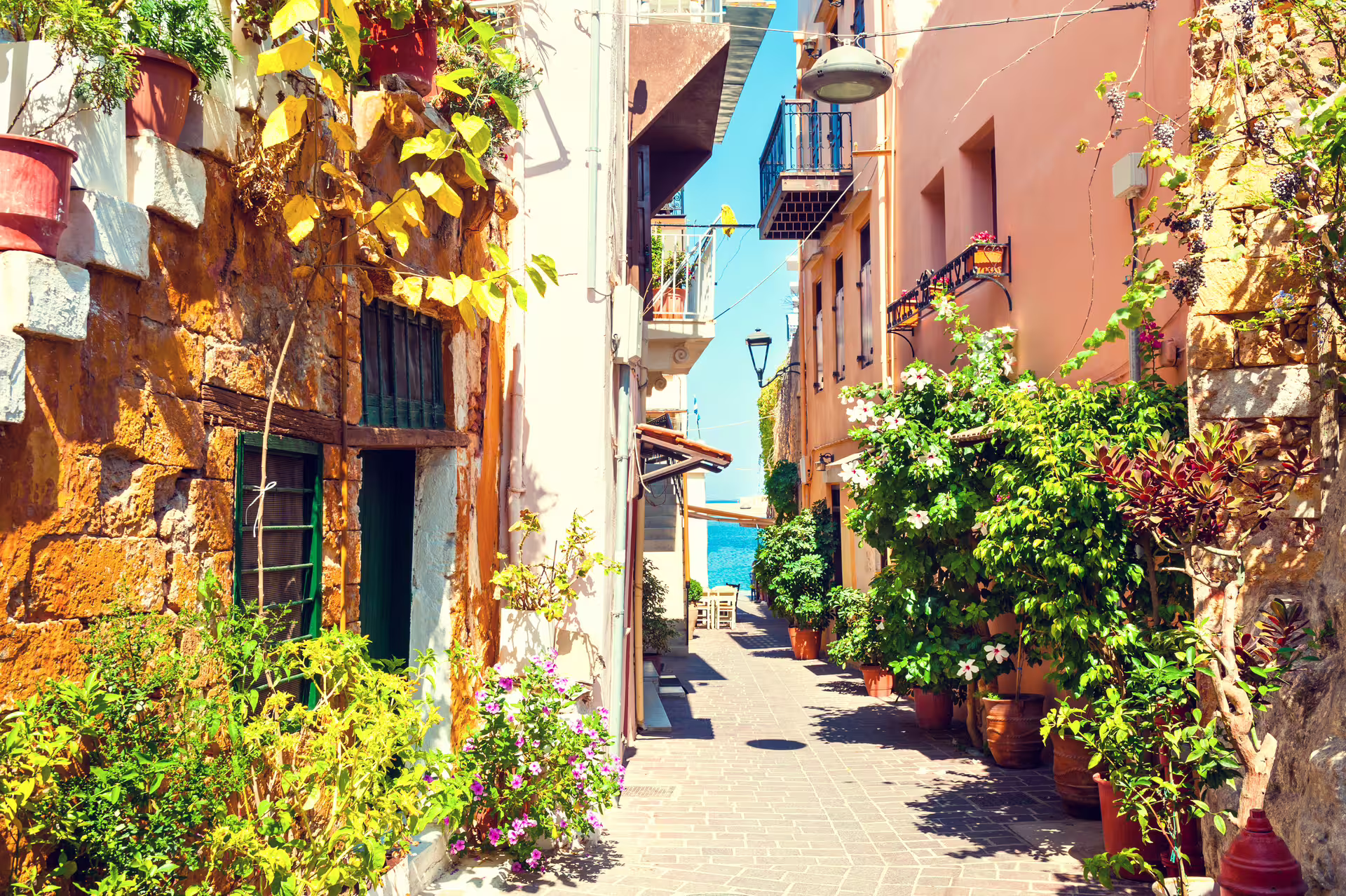 Charming Old Town Chania alley with colorful houses and potted flowers, featured on a private sightseeing tour
