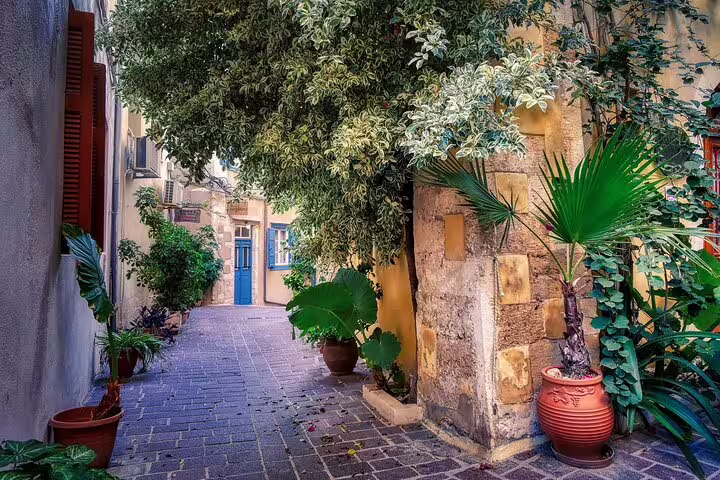Charming narrow alley in Chania Old Town adorned with lush greenery and traditional architecture.