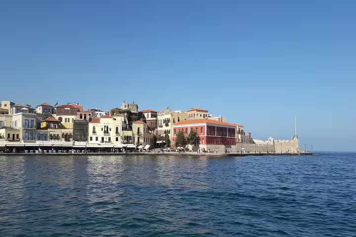 Chania Old Town waterfront with colorful Venetian buildings along the serene sea, ideal for a cultural adventure.