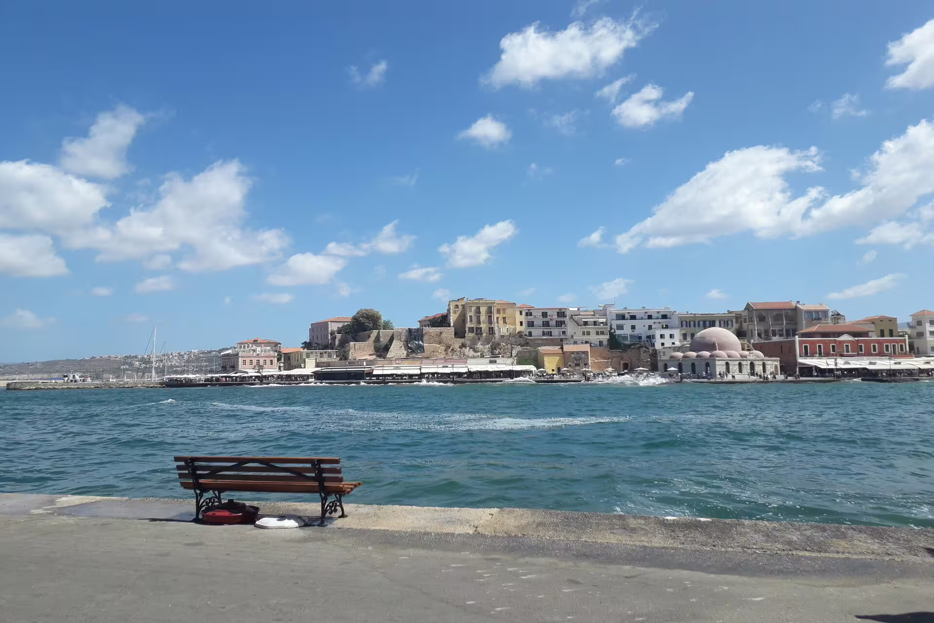 View of Chania's Venetian Harbor with a bench overlooking the sea, part of a 5-day Crete exploration tour.