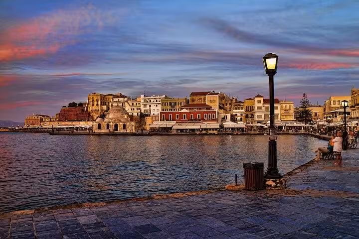 Sunset view of Chania Venetian Harbor promenade and waterfront cafes, popular stop on Rethymno to Chania tour