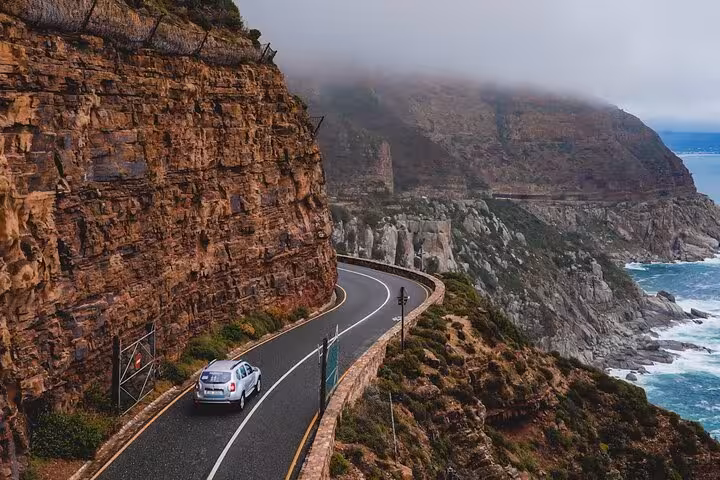 Scenic drive along Chapman's Peak with dramatic coastal cliffs and ocean views, a highlight of Cape Town adventures.