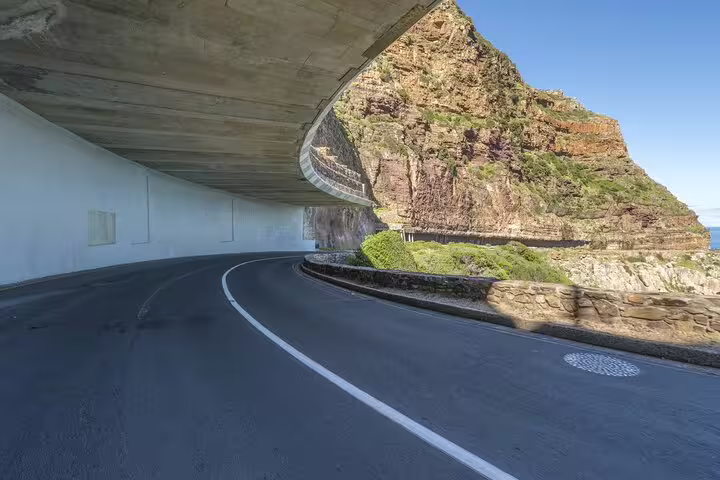 Scenic drive along Chapman's Peak with stunning coastal views on the Half Day Penguins and Cape of Good Hope Tour.
