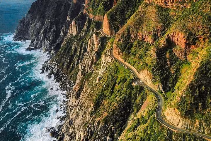 Scenic aerial view of Chapman's Peak Drive along rugged cliffs and ocean waves in Cape Town, perfect for a picturesque tour.