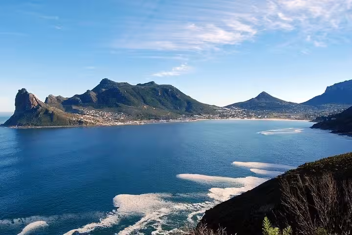 Scenic view of Hout Bay and Chapman’s Peak Drive, showcasing dramatic mountains and ocean in Cape Town.