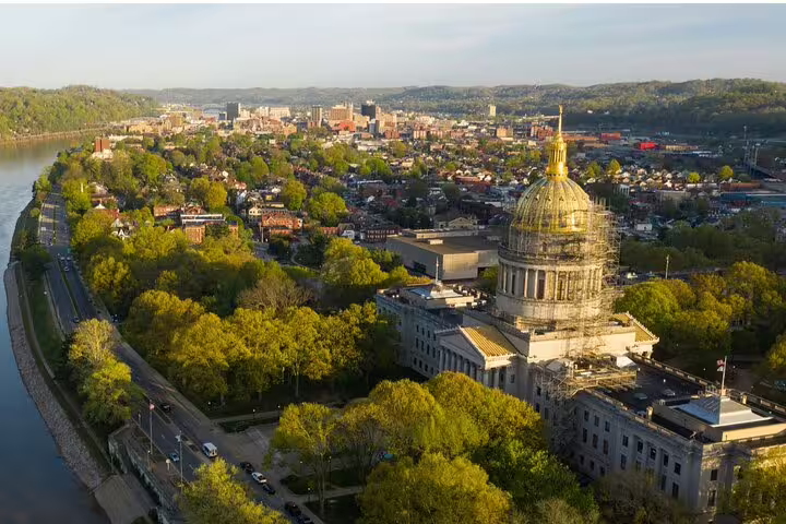 Aerial view of Charleston West Virginia state capitol building with golden dome along the Kanawha River