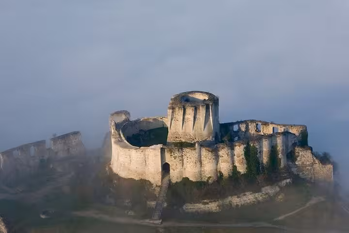 Aerial view of medieval Château Gaillard ruins shrouded in morning mist, Normandy France
