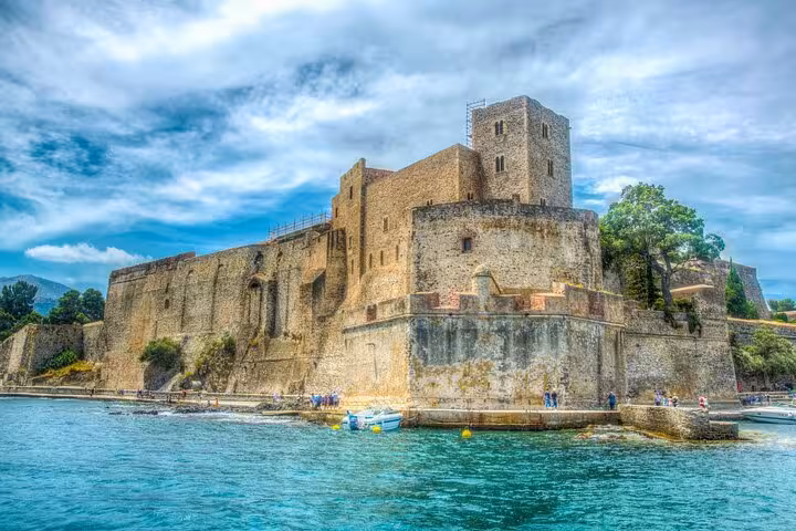 Château Royal de Collioure medieval stone fortress rising above turquoise Mediterranean harbor waters