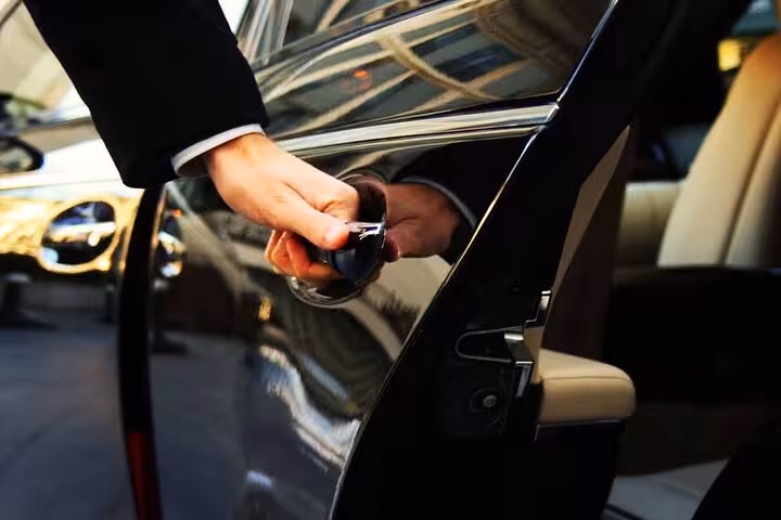 Close-up of chauffeur opening black sedan door for Sharm El Sheikh to Cairo private transfer with meet and greet