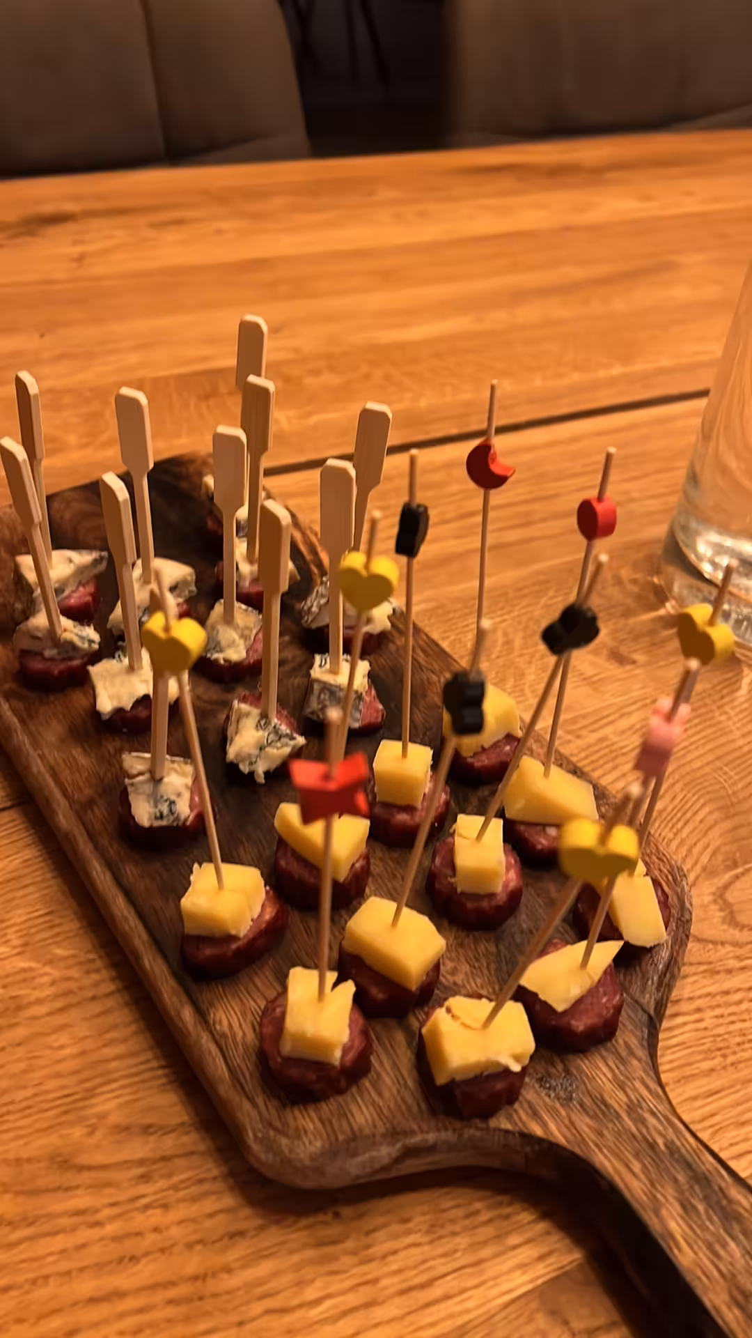 Elegant cheese and salami food pairing bites on rustic wooden board perfect for a lakeside wine tasting experience