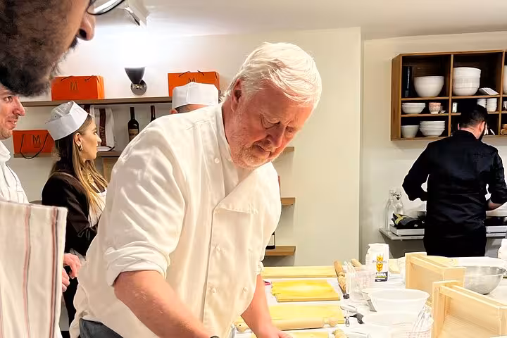 Chef instructs participants in a hands-on pasta-making class, showcasing expert techniques for fettuccine and ravioli.
