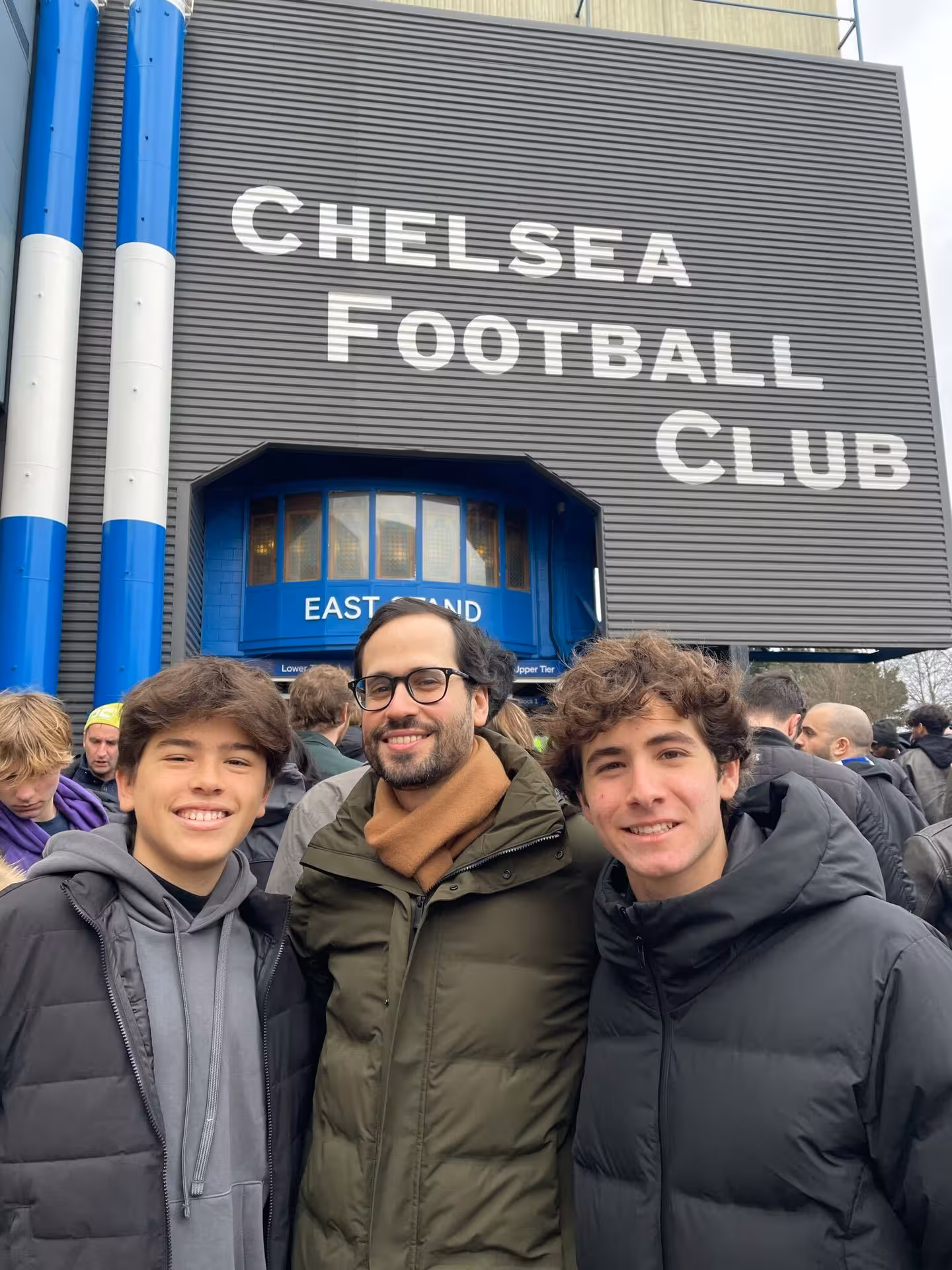 Fans with local host outside Chelsea Football Club at Stamford Bridge, London football matchday experience