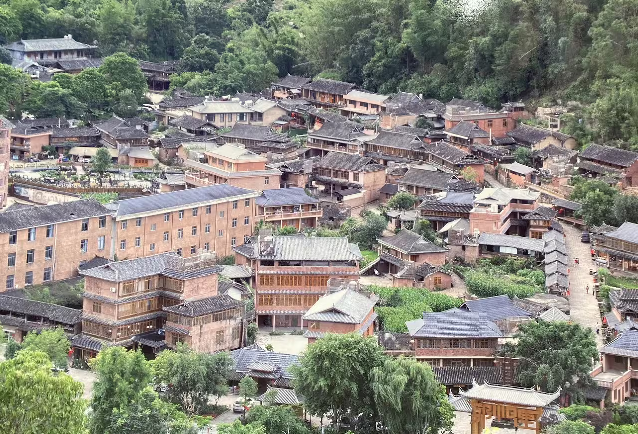 Aerial view of a traditional Chinese village nestled in lush greenery, showcasing Chengdu's cultural heritage.