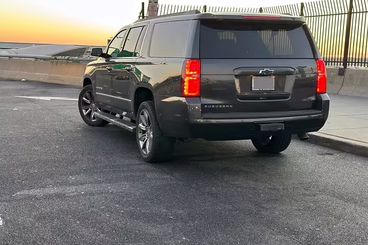 Dark gray Chevrolet Suburban SUV parked at sunset for private airport transfer service