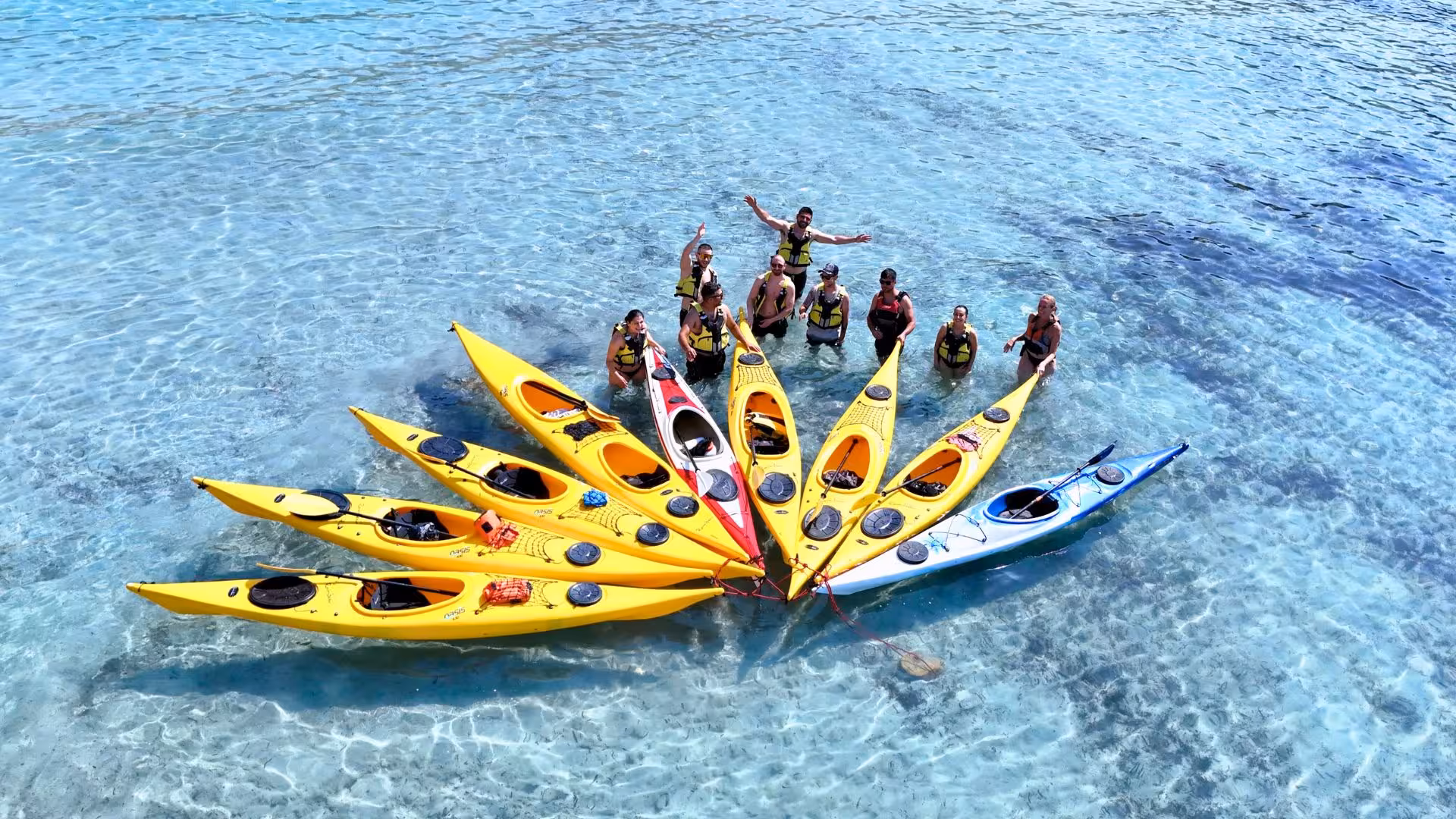 Group of kayakers forming a circle in clear turquoise waters during Tuerredda kayak tour in Chia.