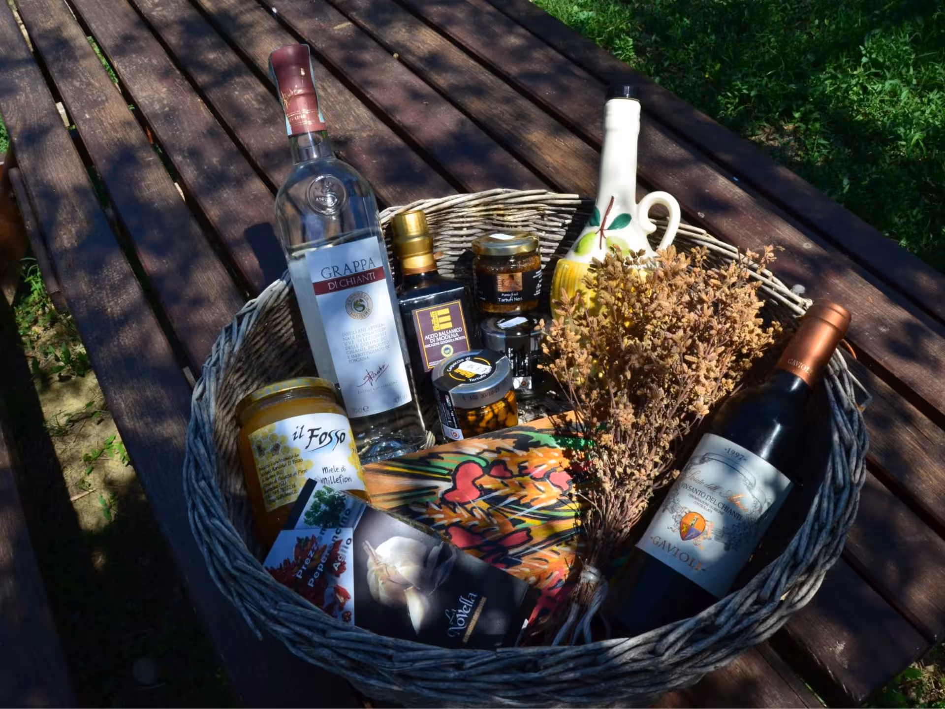 Basket of Chianciano specialties including wine, honey, and olive oil for tasting tour.
