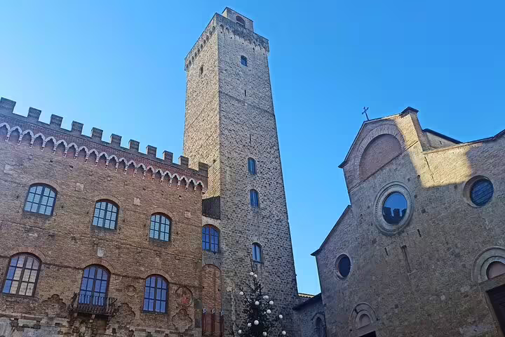 Medieval stone tower and church facade in a hilltop Chianti village, seen during a private Tuscany countryside tour