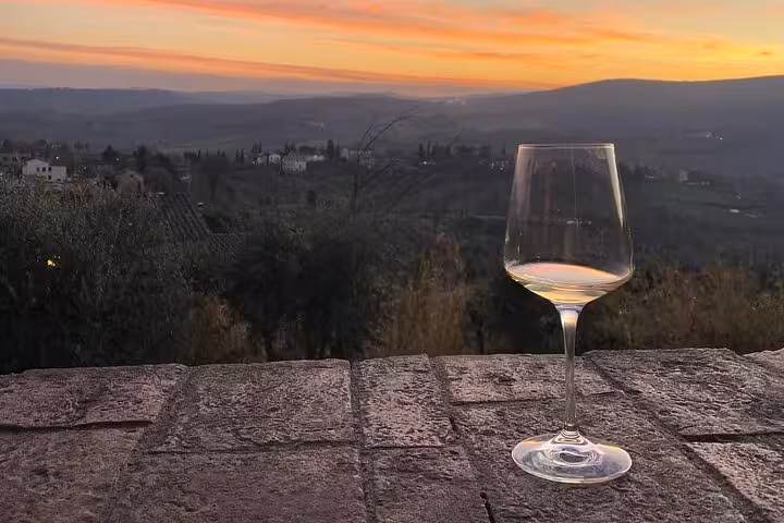 Scenic Chianti sunset with a wine glass on a rustic terrace, perfect for a private dinner and tasting tour.