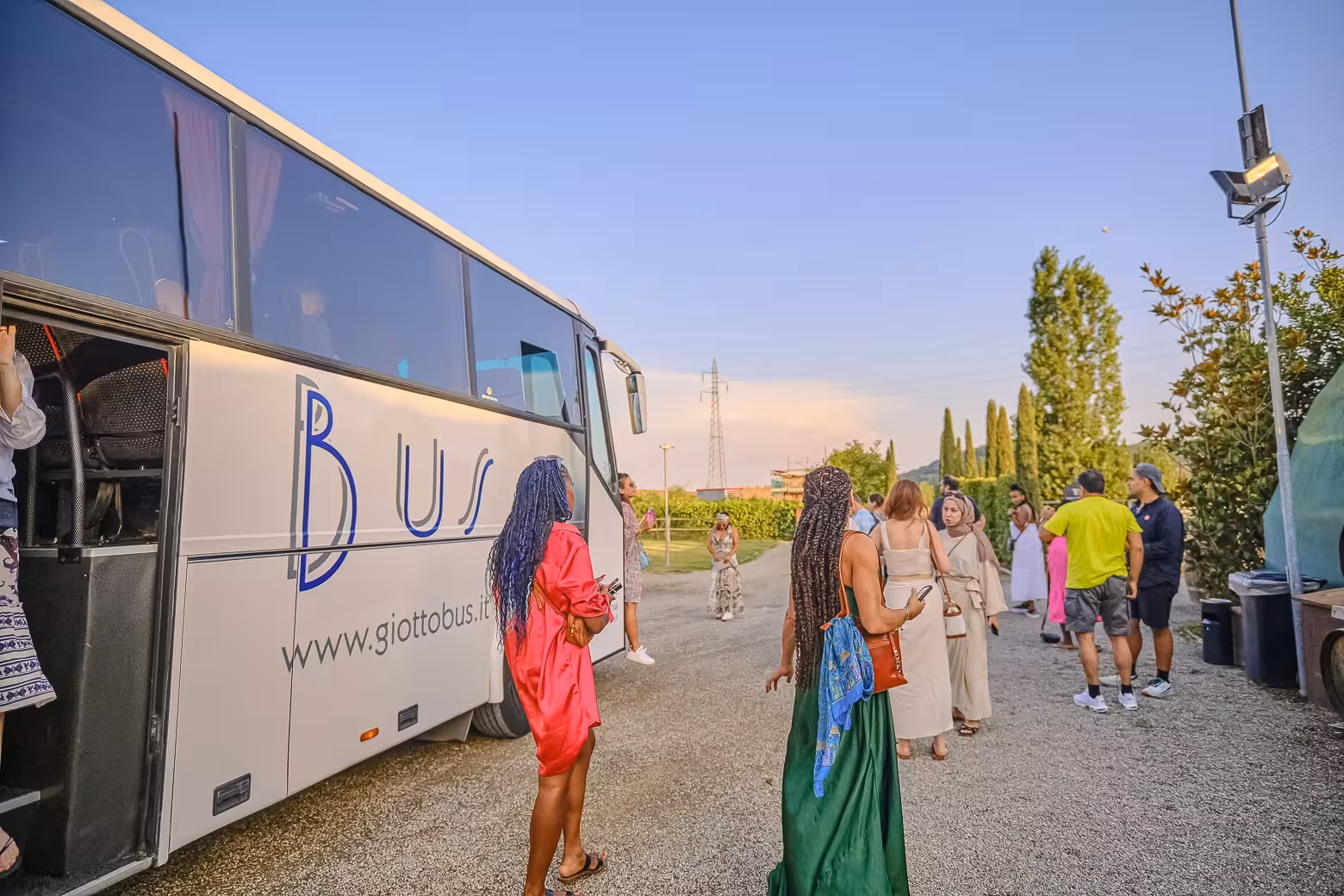 Tour group arrives by bus at a scenic vineyard, ready for the Siena and Chianti wine and dinner experience.