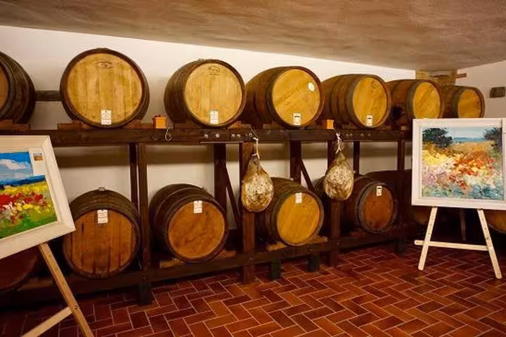 Cantina con botti di rovere per affinamento Chianti durante tour degustazione in Toscana da Firenze