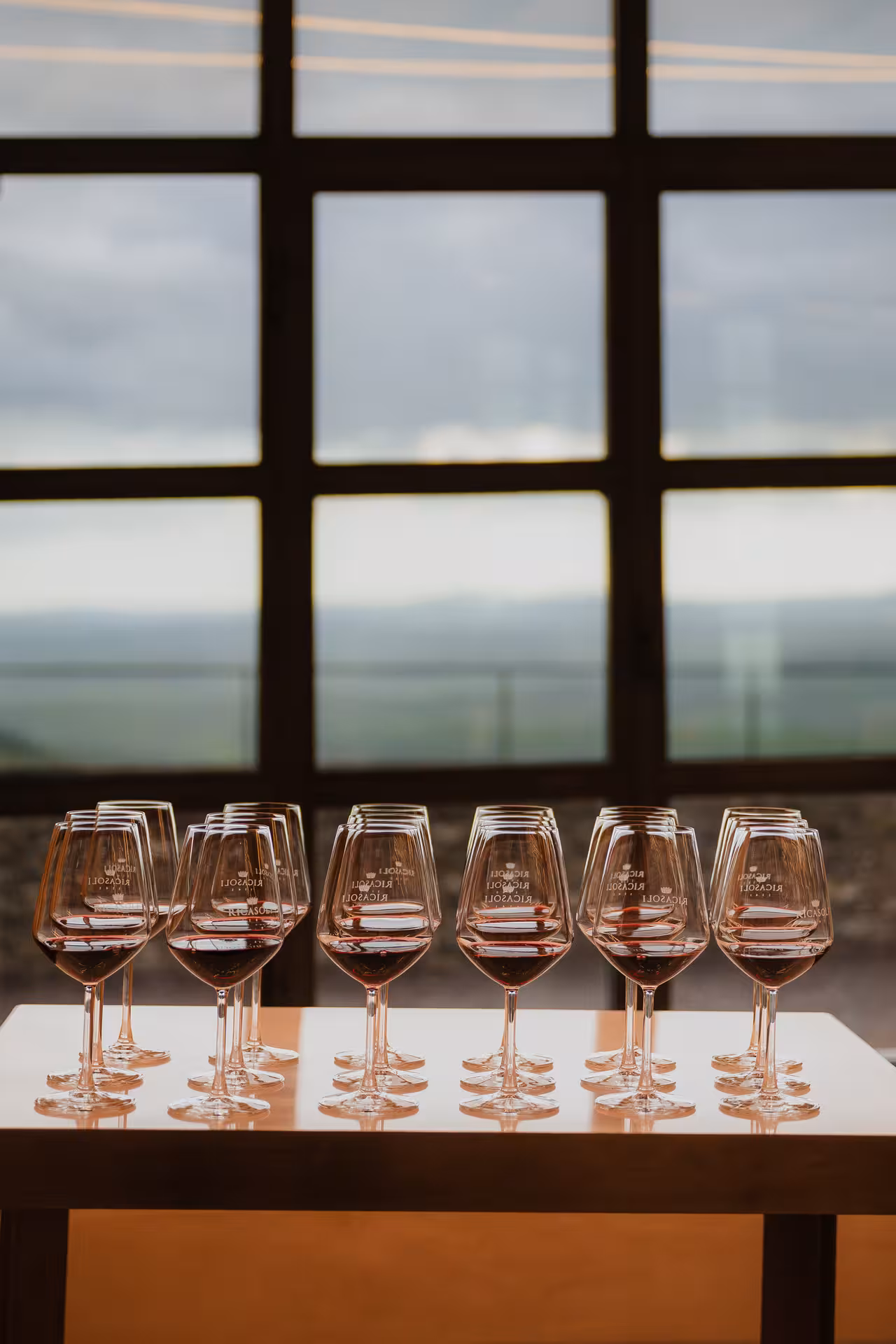 Rows of Ricasoli branded red wine glasses arranged on a table for Chianti wine tasting in Siena