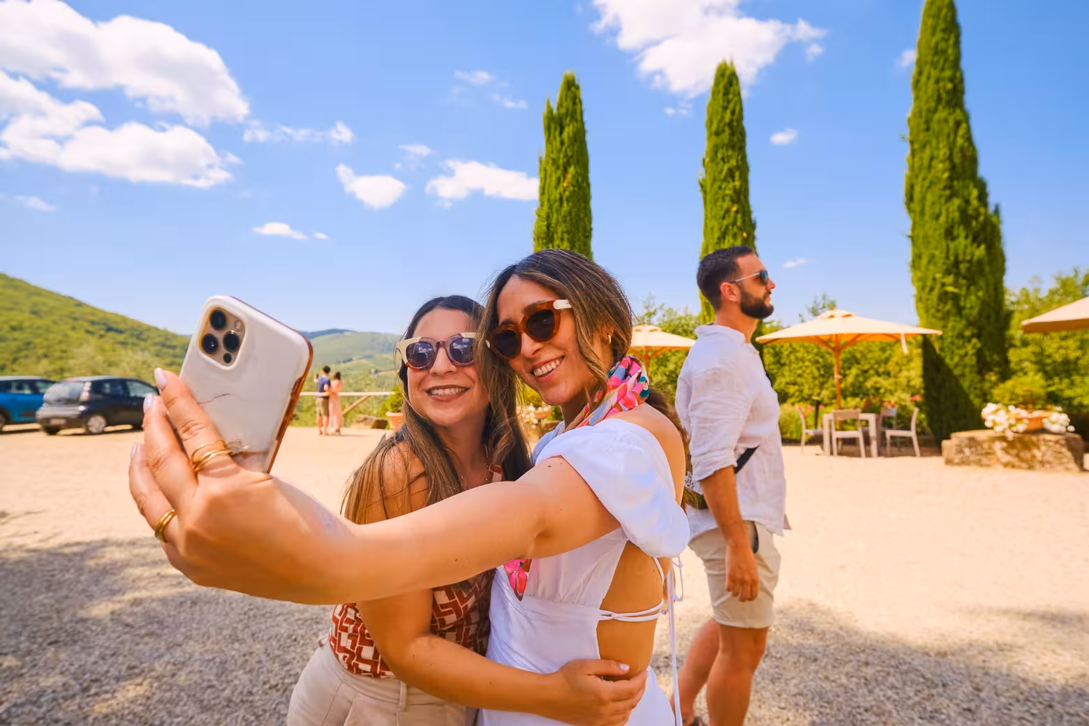 Two friends taking a selfie surrounded by picturesque Chianti landscape on a private wine tour.