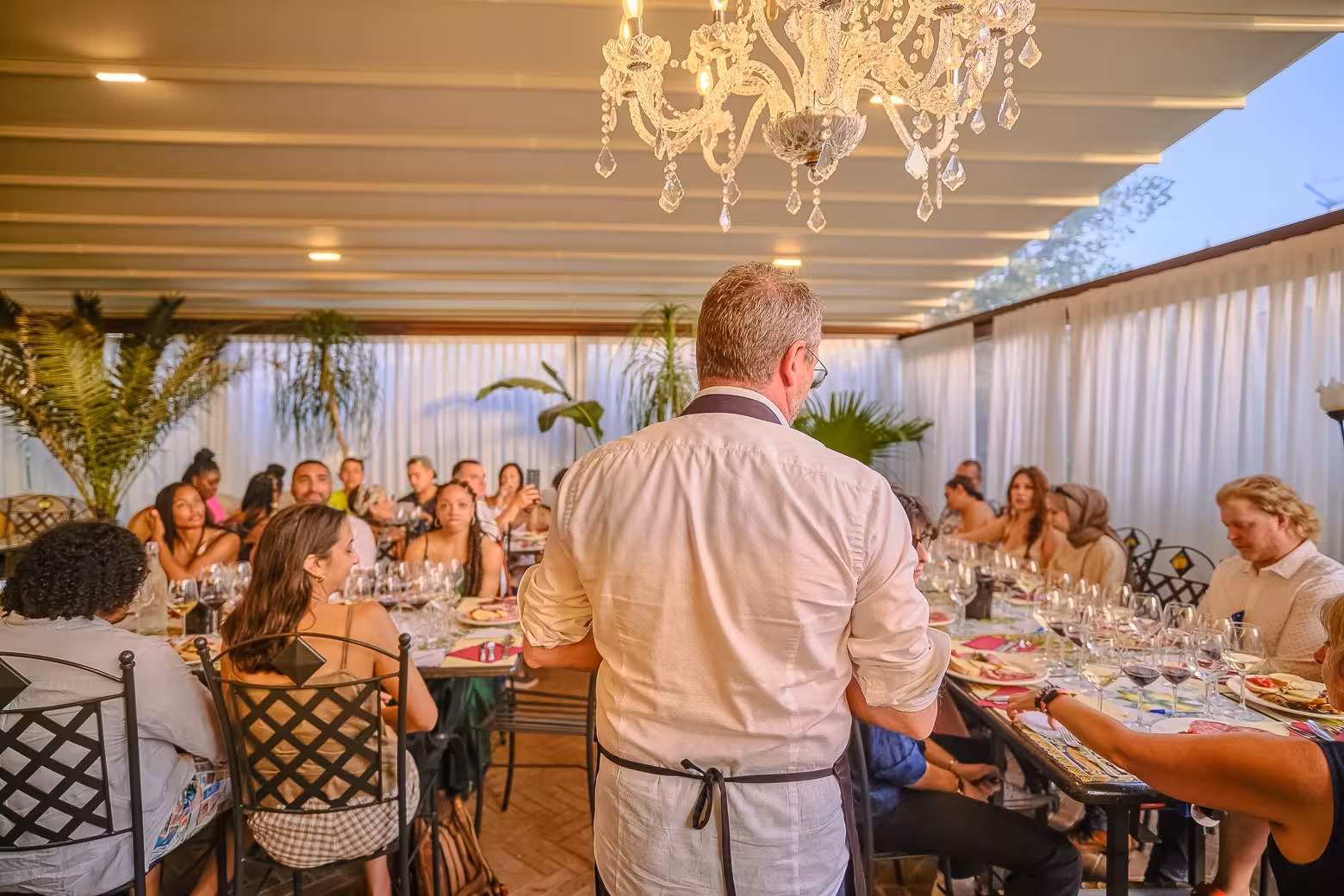 Host presenting to guests at a dining event on the Siena and Chianti wine tour from Florence.