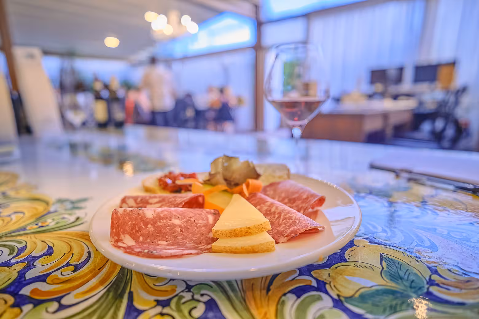 Close-up of a charcuterie platter with salami and cheese paired with wine at a Chianti winery tasting event.