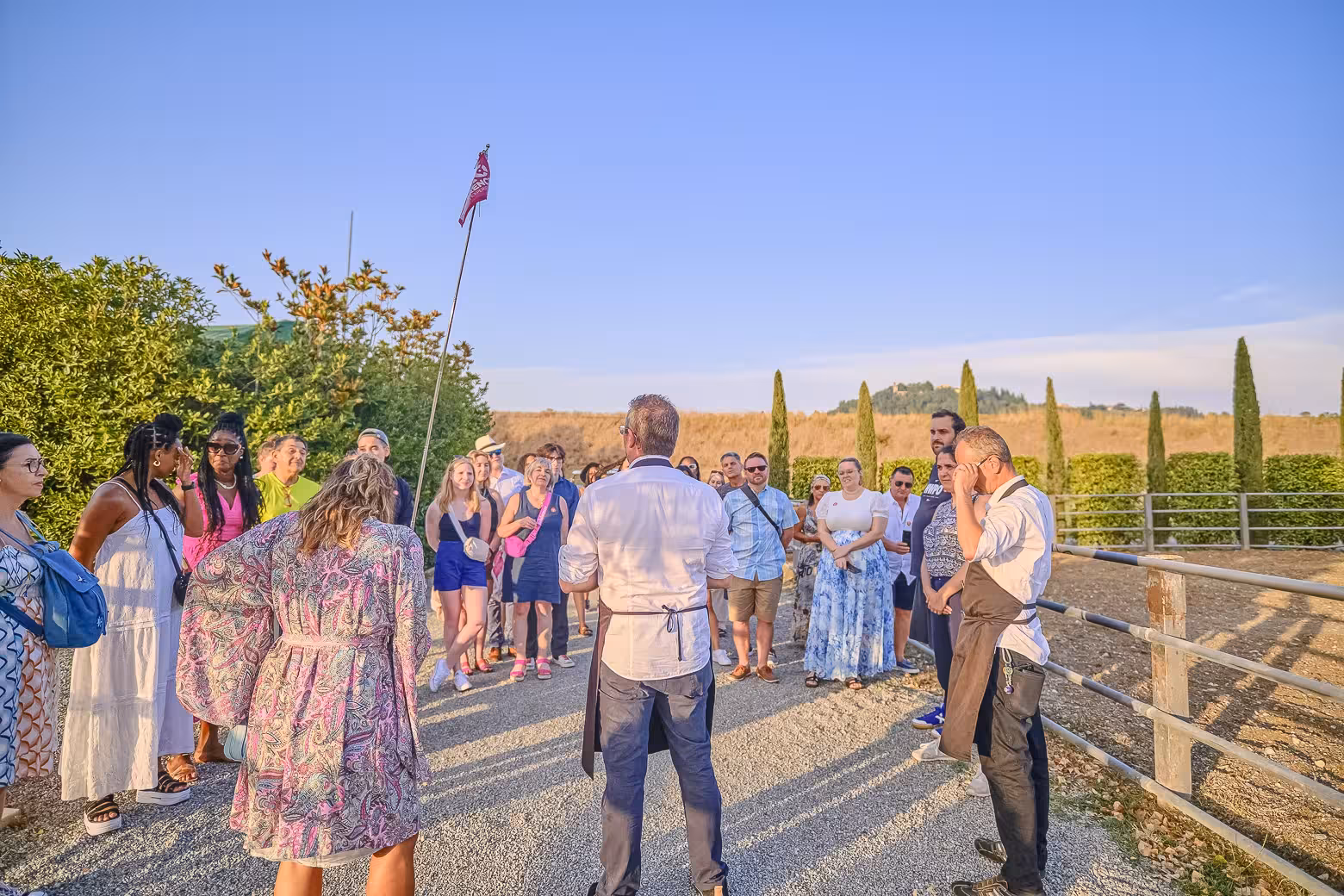 Visitors gather for a guided tour in Chianti's scenic vineyard during a small-group winery experience.