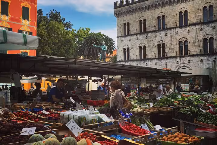 Bustling outdoor market in historic Chiavari center, showcasing fresh produce on a vibrant food tour stop.