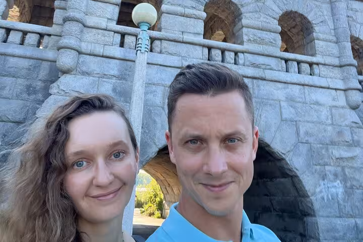 Couple smiling in front of a stone castle-like structure in Lincoln Park Chicago