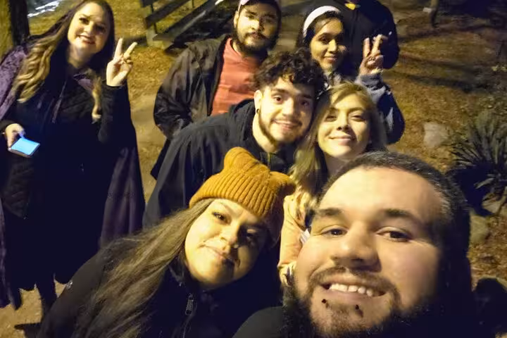 Group of friends taking a nighttime selfie during a ghost walking tour in Lincoln Park Chicago