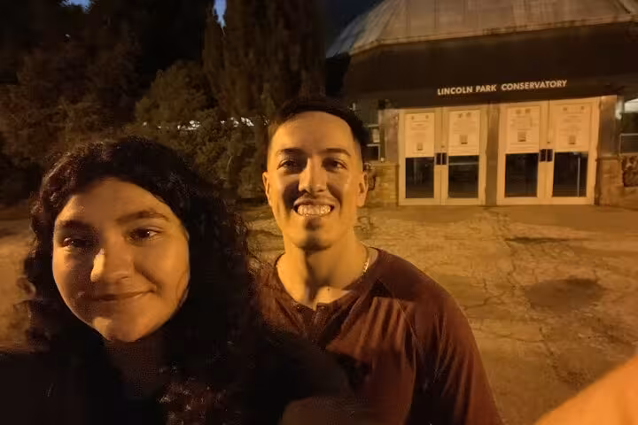 Couple smiling at night outside Lincoln Park Conservatory in Chicago