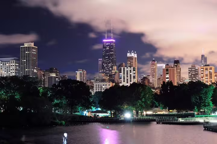 Chicago Lincoln Park skyline at night with glowing city lights and John Hancock Center illuminated in purple