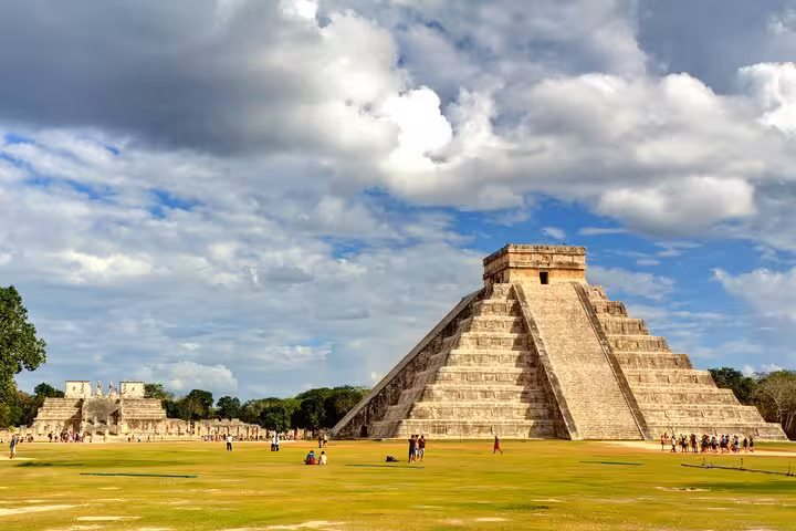 Iconic El Castillo pyramid at Chichen Itza with tourists exploring UNESCO World Heritage site on private day tour
