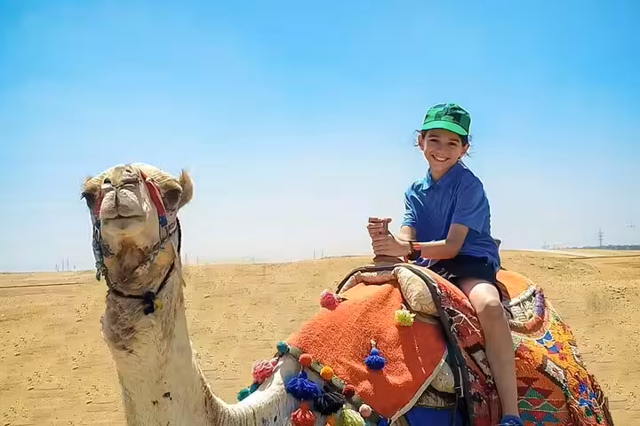 Child riding a decorated camel in the Giza Desert near Cairo, classic experience on a 3-day highlights tour