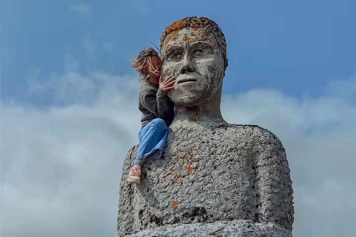 Child climbing large stone statue in the Westfjords near Isafjordur, Iceland